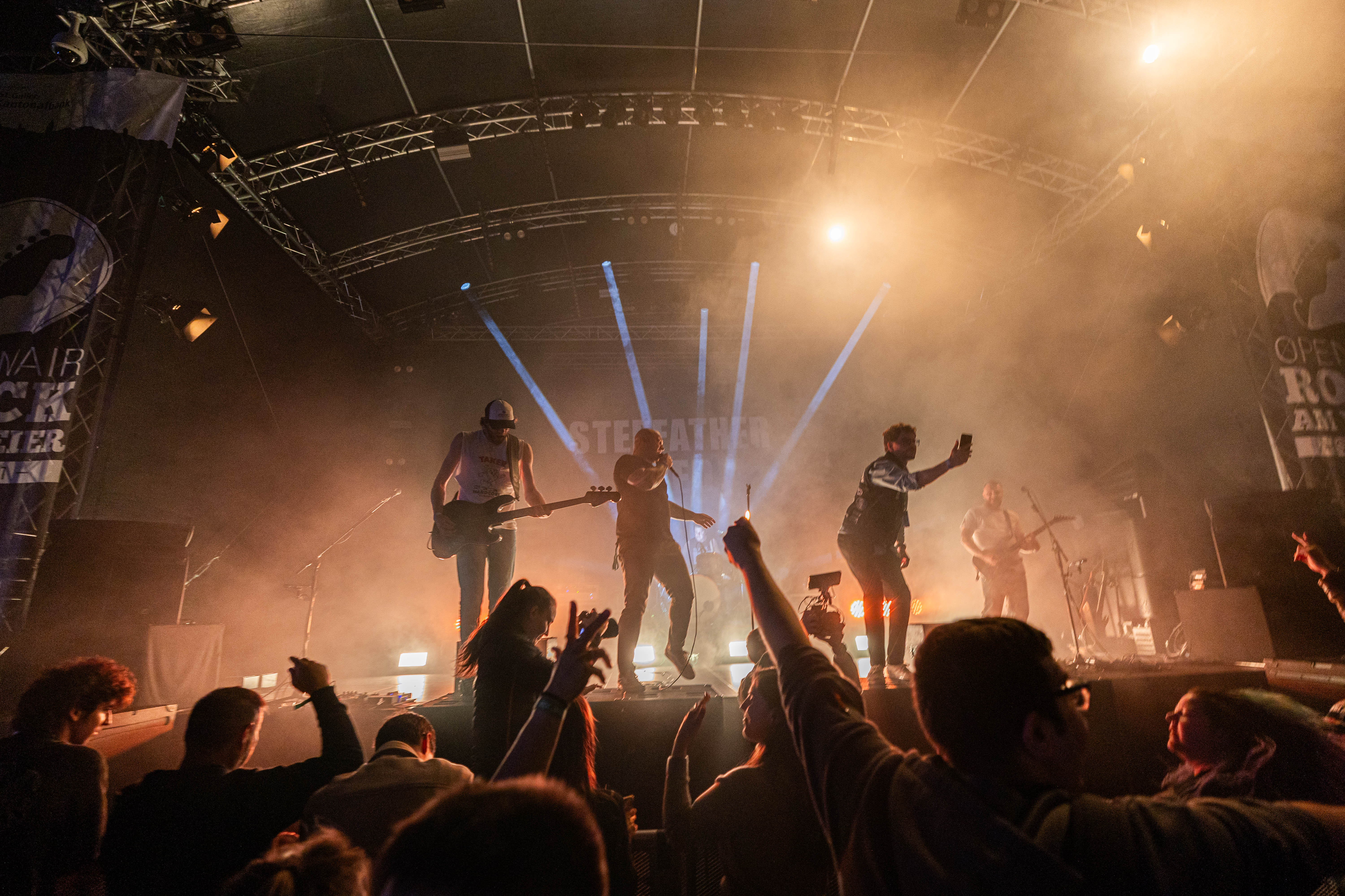 Band und Publikum in warmem Bühnenlicht bei einem Open-Air-Konzert