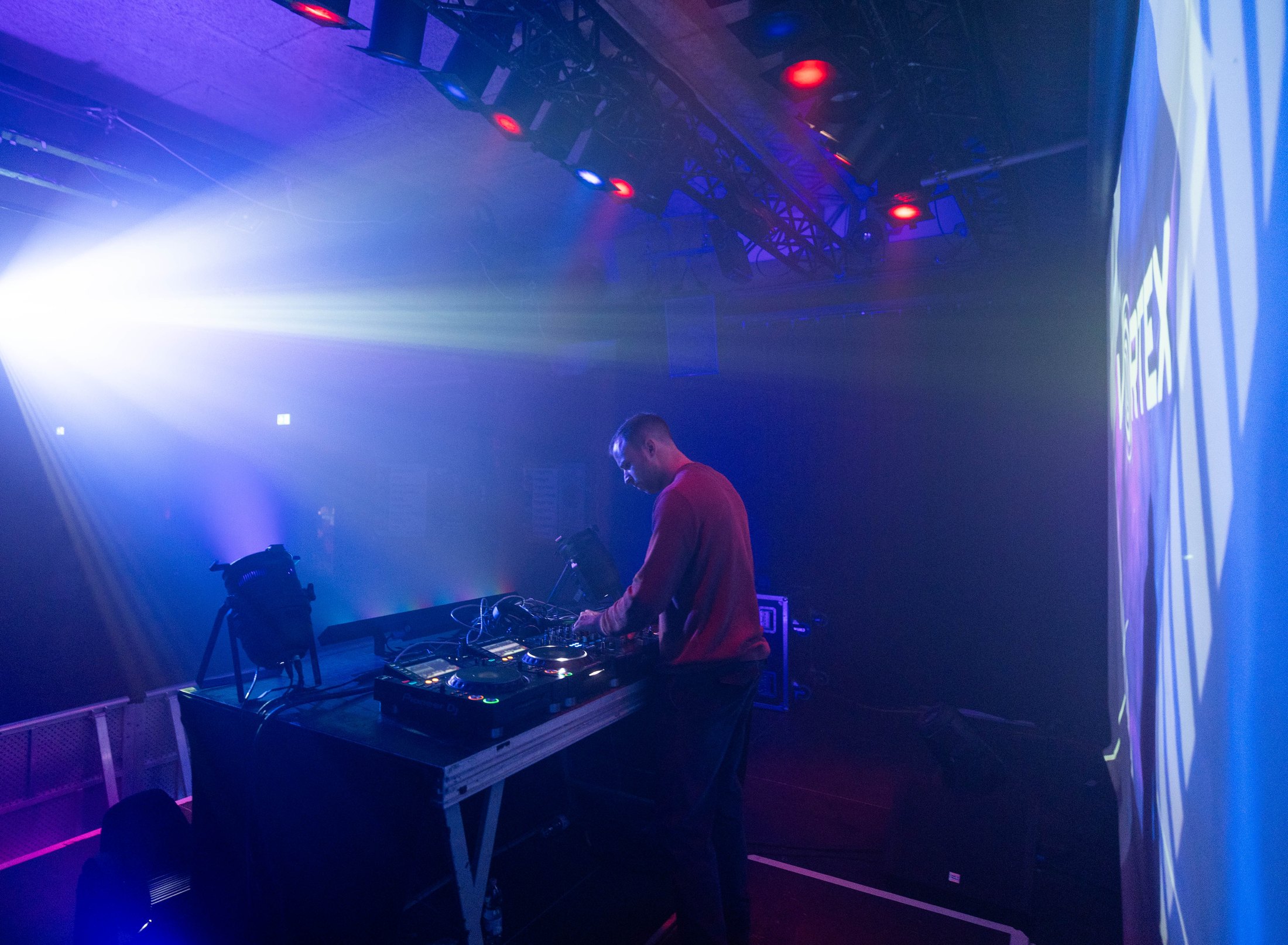 Clubszene mit DJs und diagonalen Lichtstrahlen