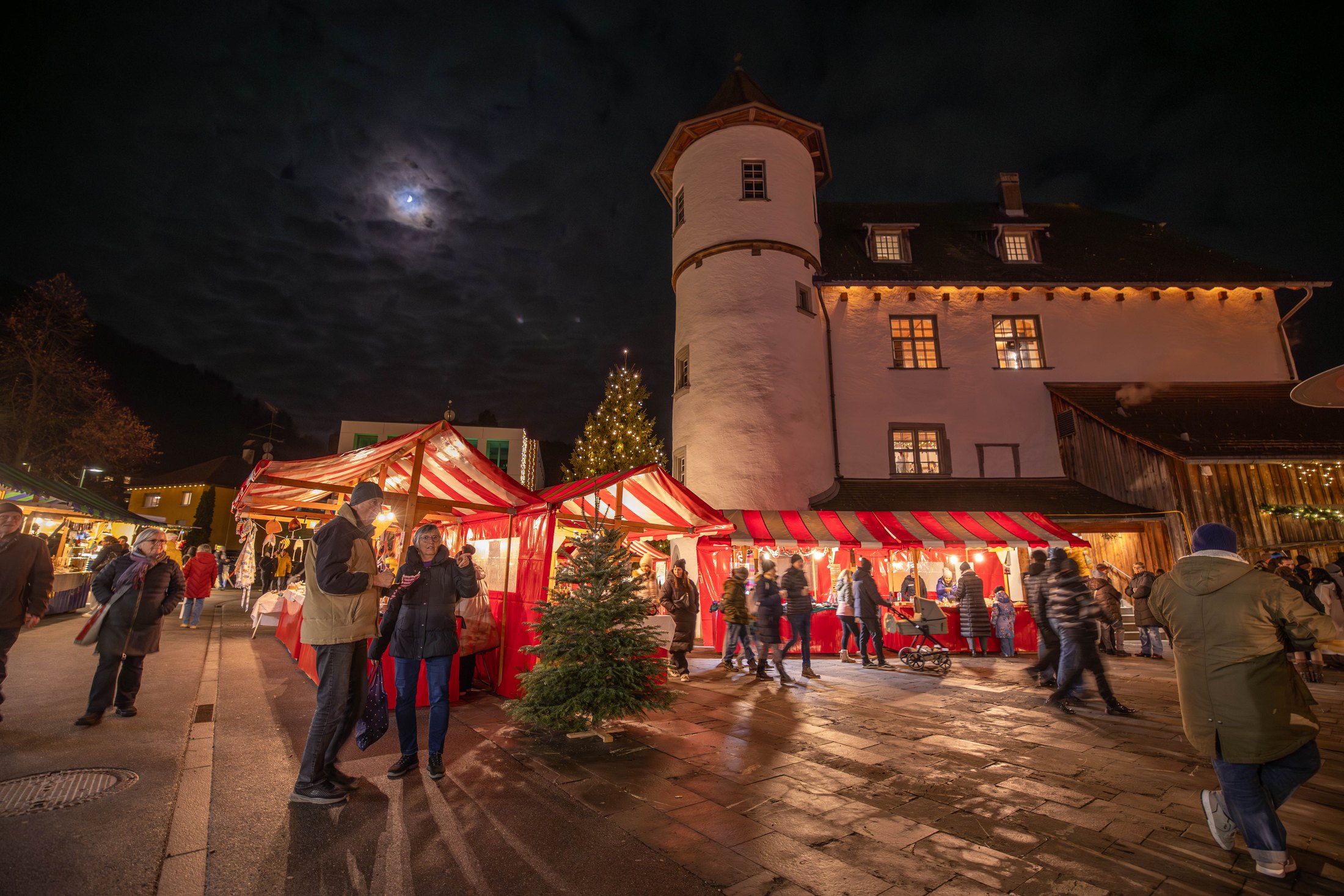 Stimmungsvoll beleuchteter Weihnachtsmarkt vor historischer Kulisse